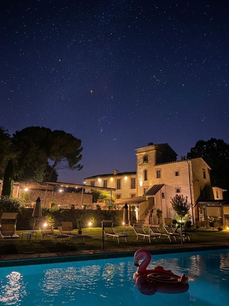 A nighttime view of a hotel with a swimming pool, a flamingo float, and a starry sky.