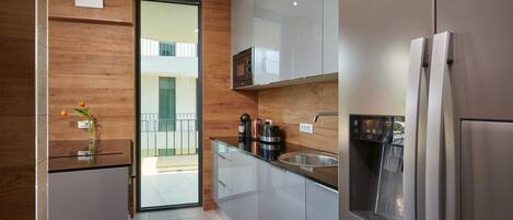 A modern kitchen with a built-in oven, microwave, and stainless steel refrigerator.