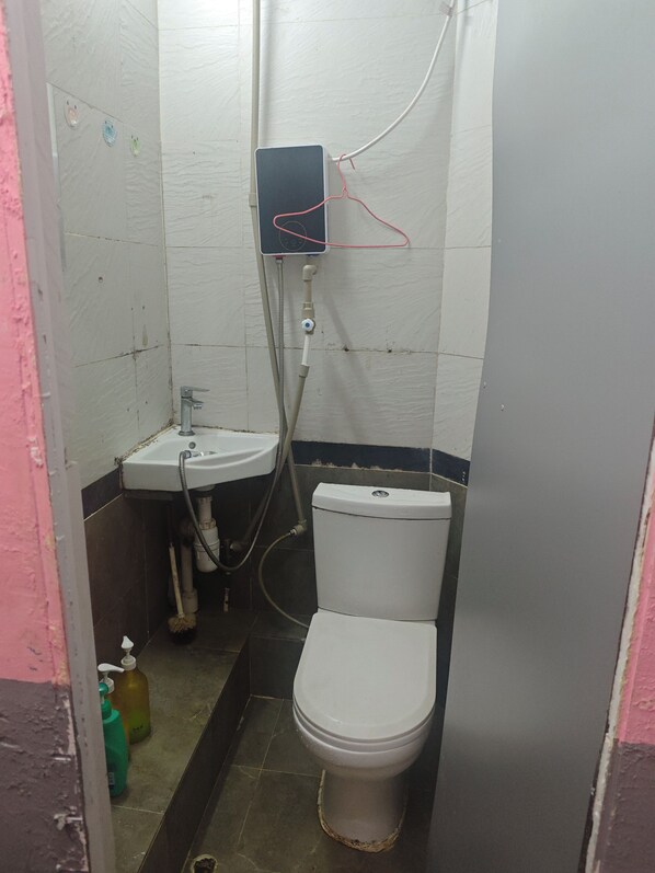 A small, compact bathroom with a toilet, sink, and shower. - Master Inn - Hostel (Kowloon)