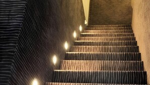 A carpeted staircase with a striped pattern and a handrail on the left. - Sleephotels (Hamburg)