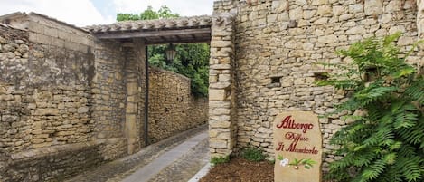 Un edificio de piedra con un cartel que dice "Albergo Diffuso Il Manderlo".