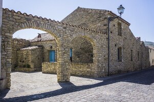 Un edificio de piedra con arcos y una calle adoquinada.