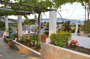 A rooftop garden with stone walls, potted plants, and a pergola. - Sofia (Apokoronas)