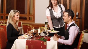 A dining table set with wine glasses, a candle, and a rose. - Hotel Lafonte (Karlovy Vary)