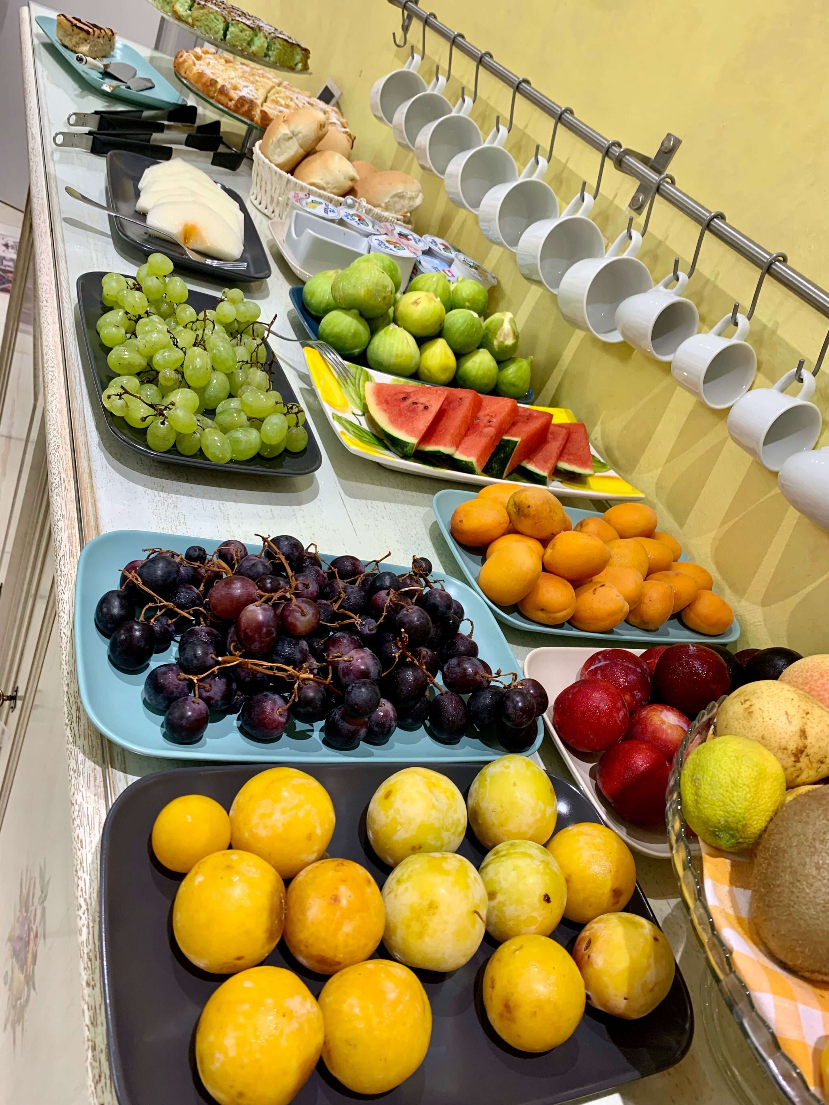 A buffet with various fruits and pastries.