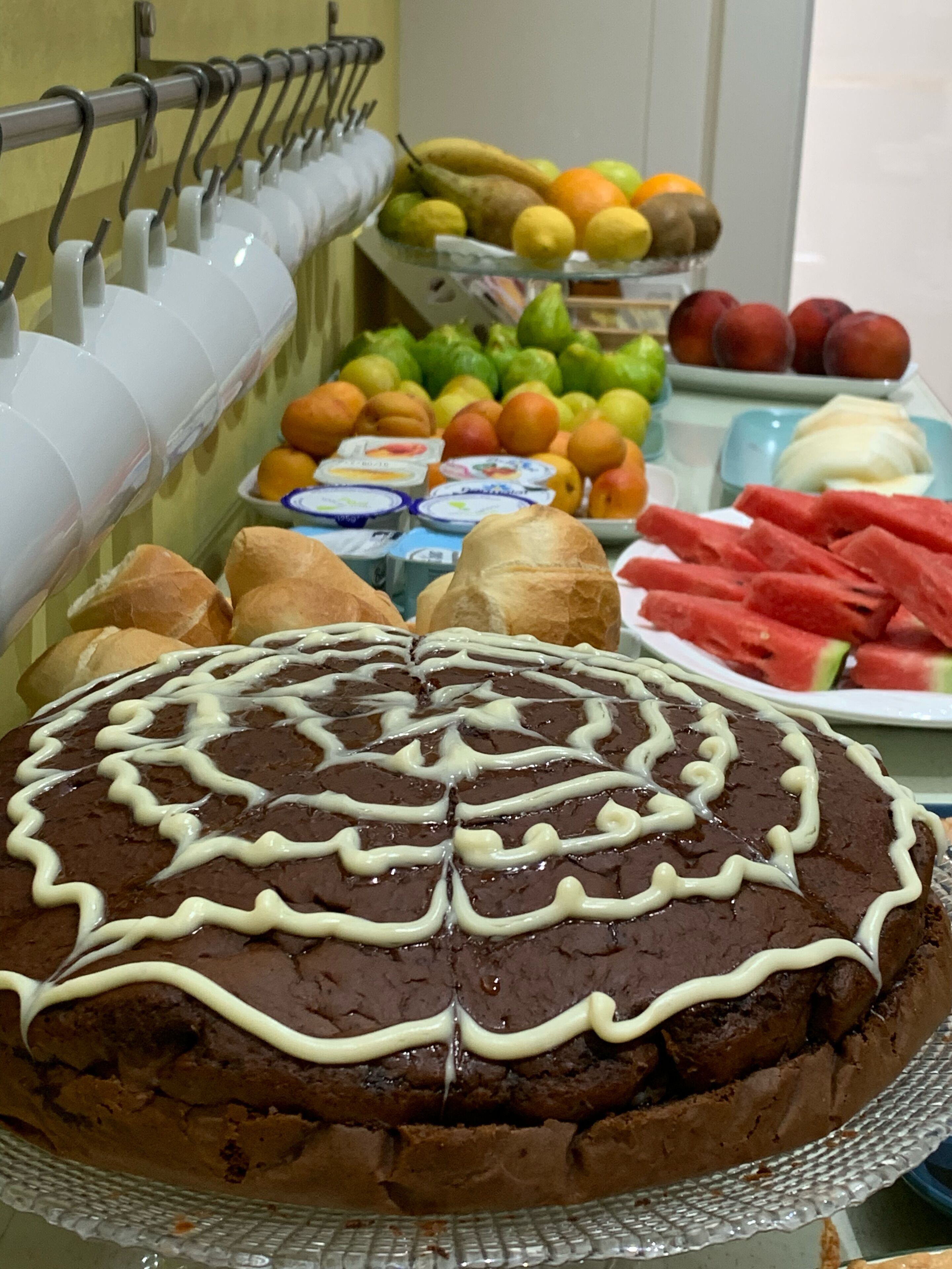 Una mesa de postres con pastel de chocolate, frutas y parfait de yogur.