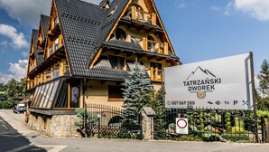 A traditional wooden house with a signboard for Tatranski Dworek. - Tatrzański Dworek (Bialy Dunajec)
