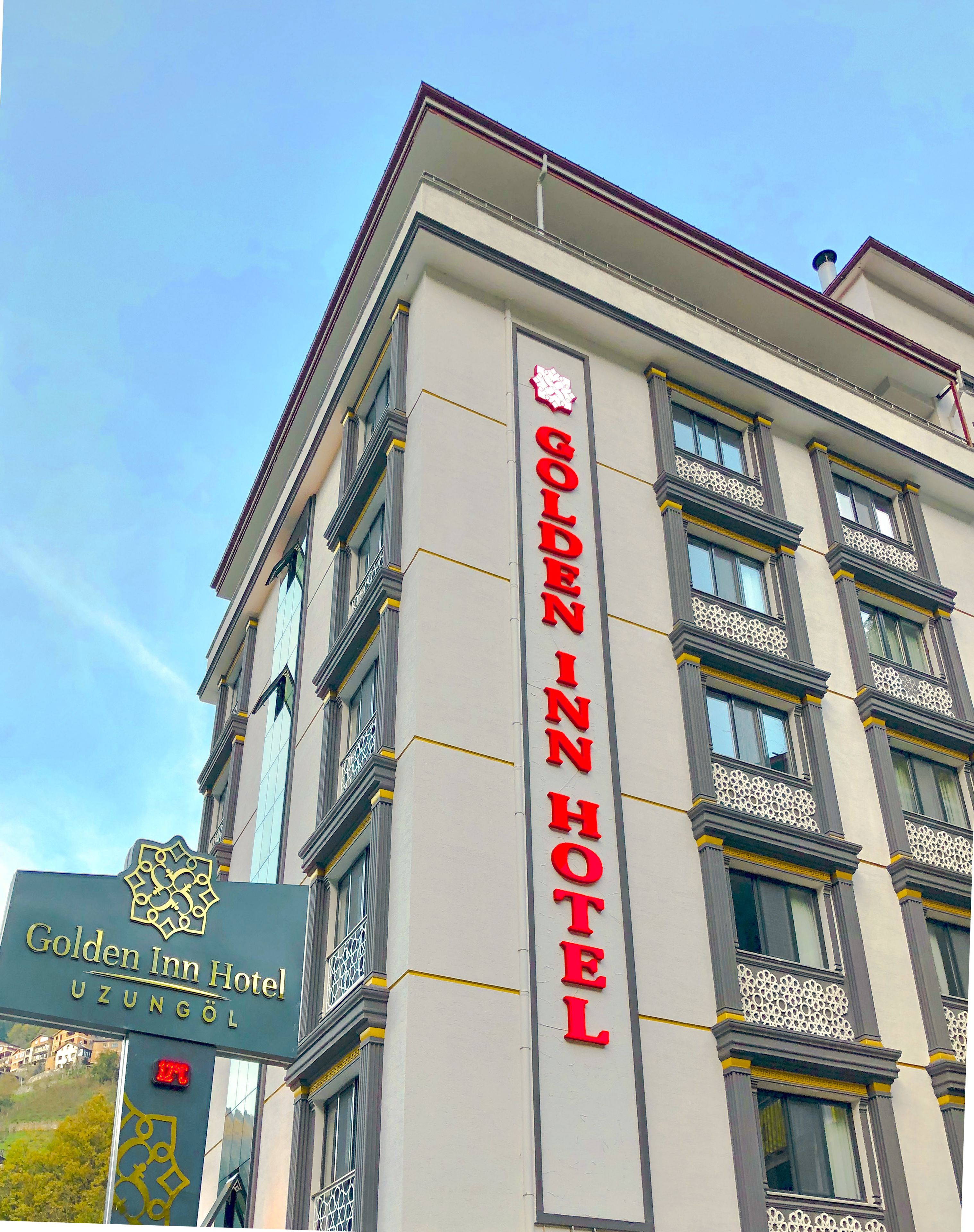 The exterior of the Golden Inn Hotel with a prominent sign and a view of the building's facade.