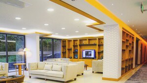 A modern hotel lobby with a large seating area, a television, and a view of the outdoors. - Golden Inn Hotel Uzungol (Çaykara)