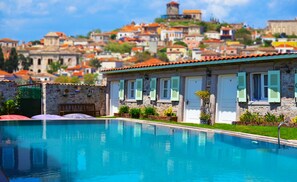 Una piscina con un edificio de piedra al fondo.