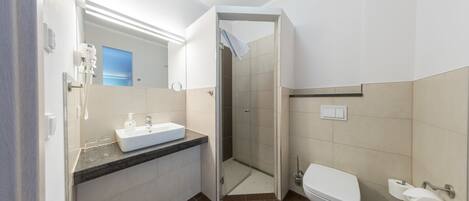 A modern bathroom with a sink, toilet, and shower.