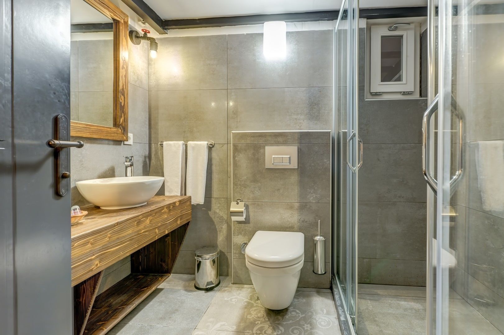 A modern bathroom with a large sink, toilet, and shower area.