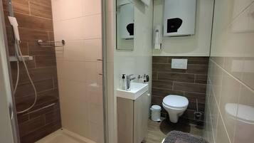 Apartamento Confort, 1 habitación | Baño | Ducha, cabezal de ducha tipo lluvia, secador de pelo y toallas
