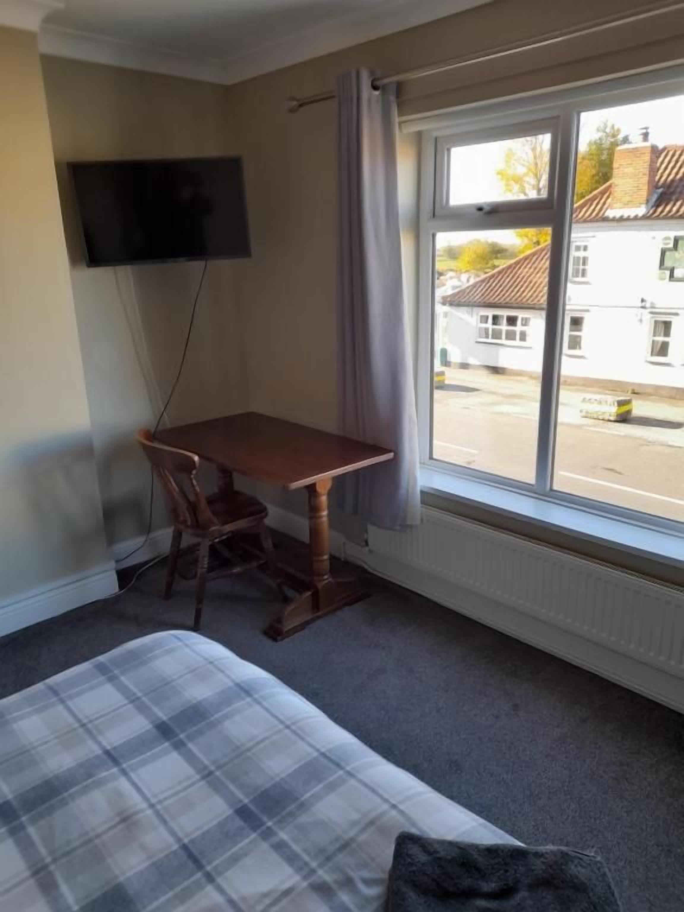 A room with a bed, a desk, and a television.