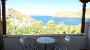 Ein Balkon mit Blick auf das Meer, ein Tisch und zwei Stühle.