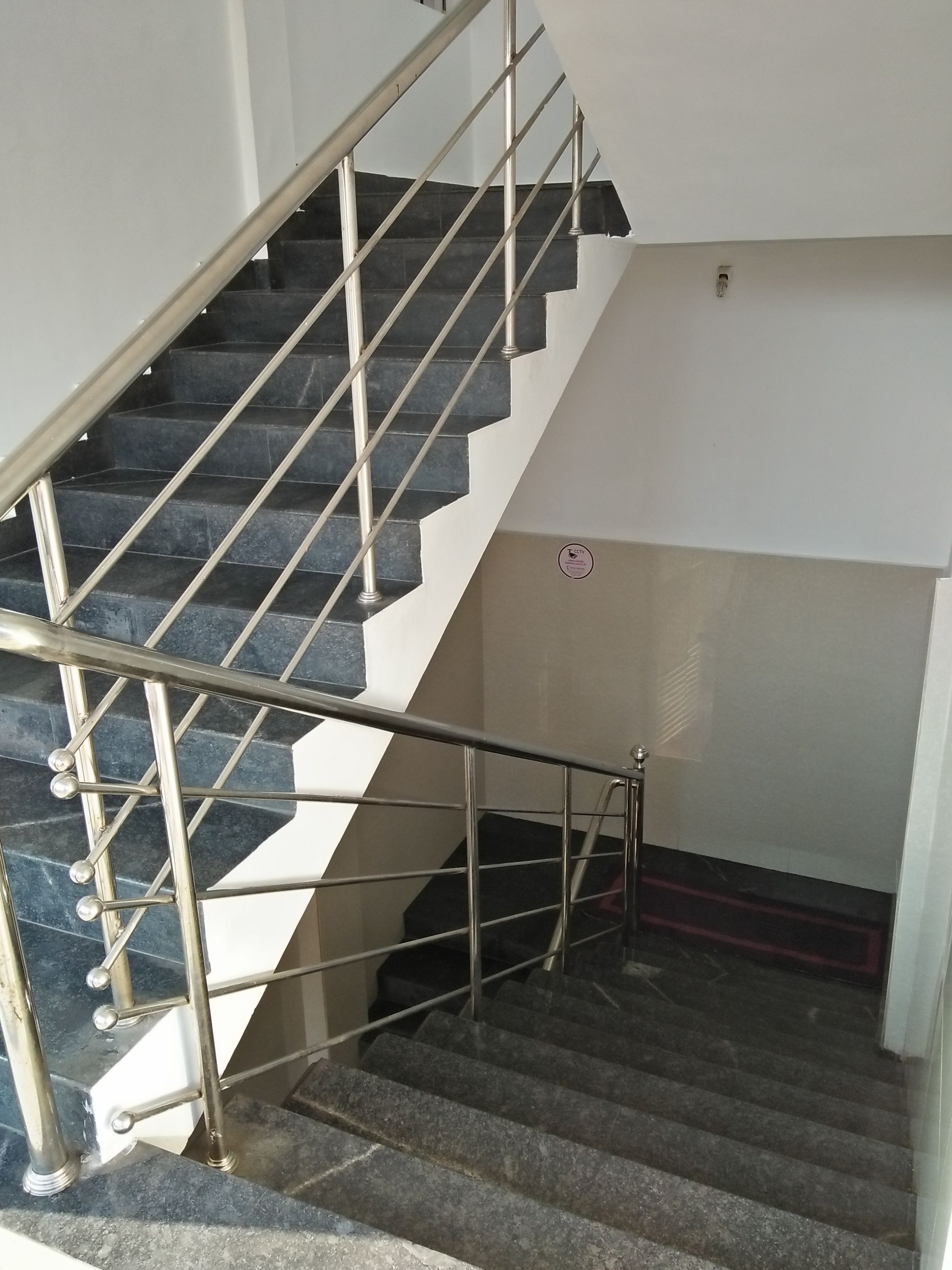 A staircase with metal railings and dark steps.