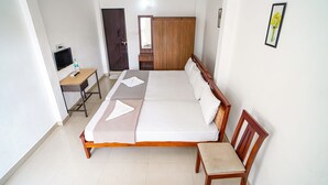 A neatly arranged bedroom with a bed, bedside table, chair, and a wardrobe.