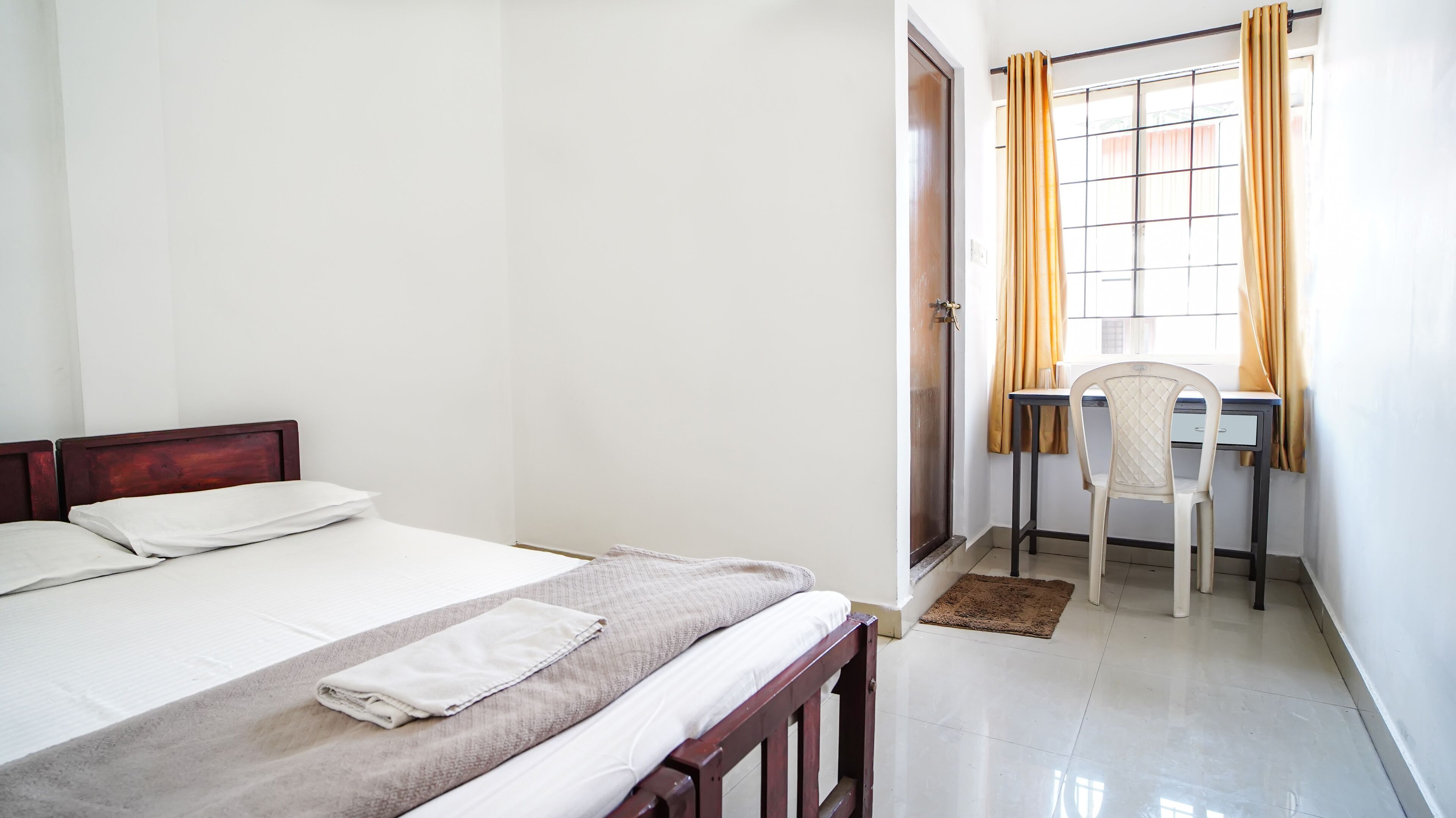 A room with a bed, a desk, and a chair.
