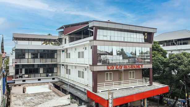 A multi-story building with a modern design, featuring large windows and a prominent signage for "Kay Kay Residency".