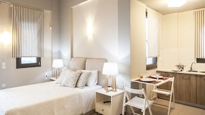 A modern hotel room with a bed, bedside tables, a desk, and a kitchenette. - Alivia Lefkas (Lefkada)