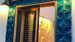 A building entrance with a decorative blue door and a patterned wall. - Incitta Otel (Seferihisar)