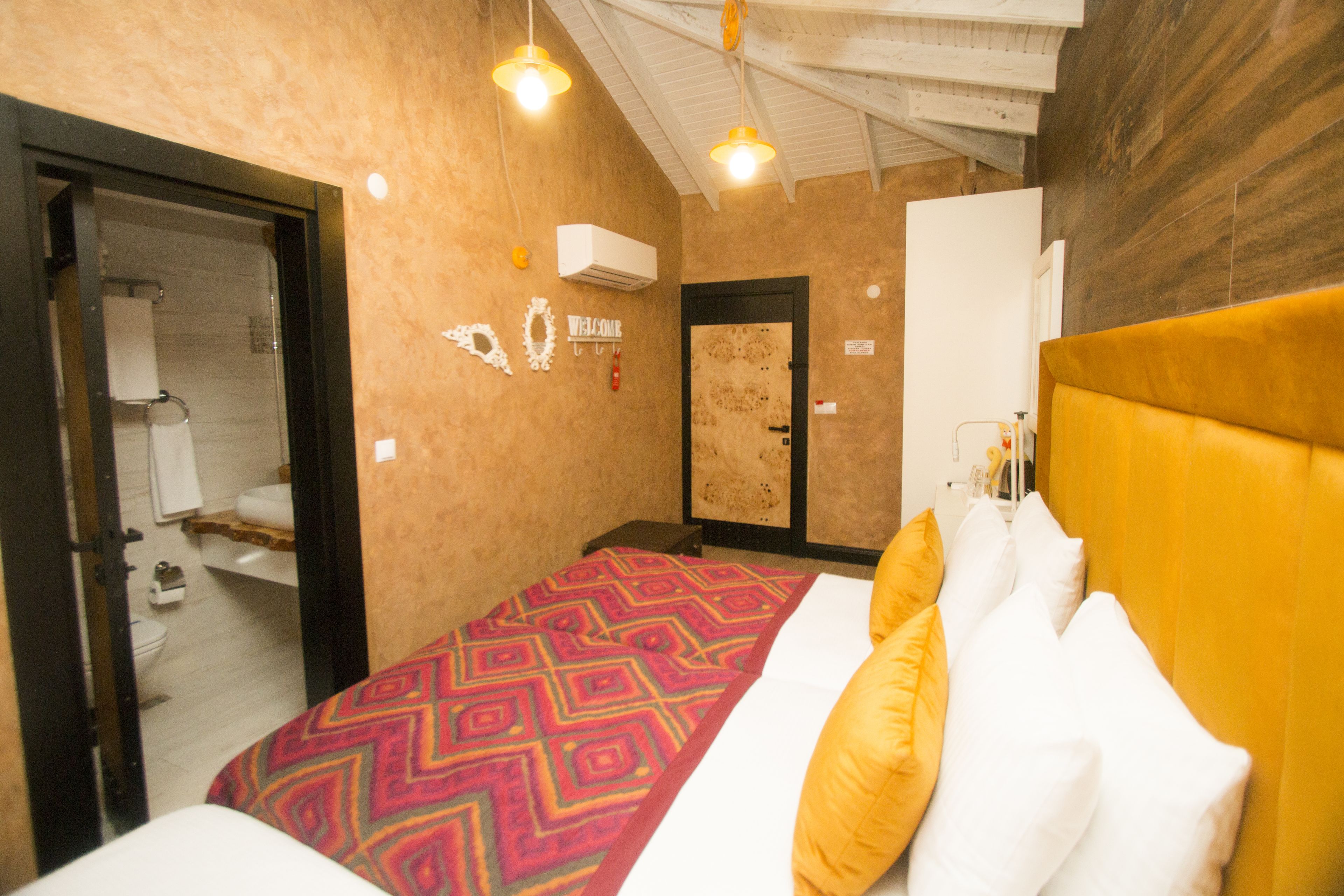 A hotel room with a bed, a bathroom, and a door.