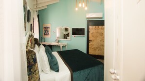 A bedroom with a bed, a desk, a chair, a mirror, and a door. - Incitta Otel (Seferihisar)