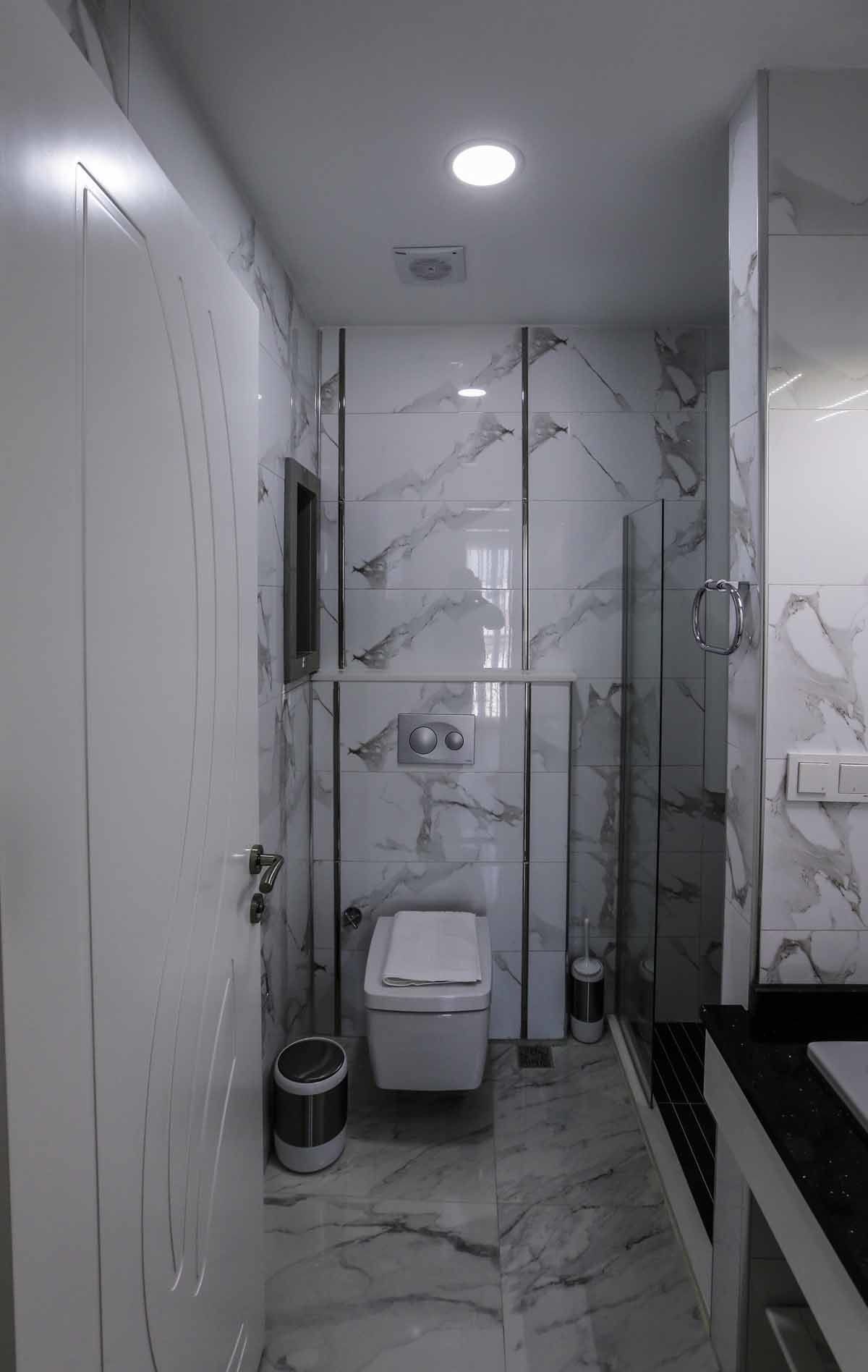 Un baño moderno con inodoro, bidé y cabina de ducha de cristal.
