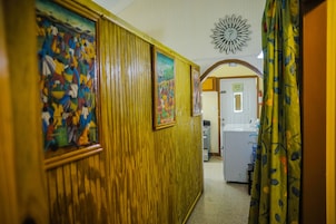 Un pasillo con paneles de madera y coloridas obras de arte en las paredes.