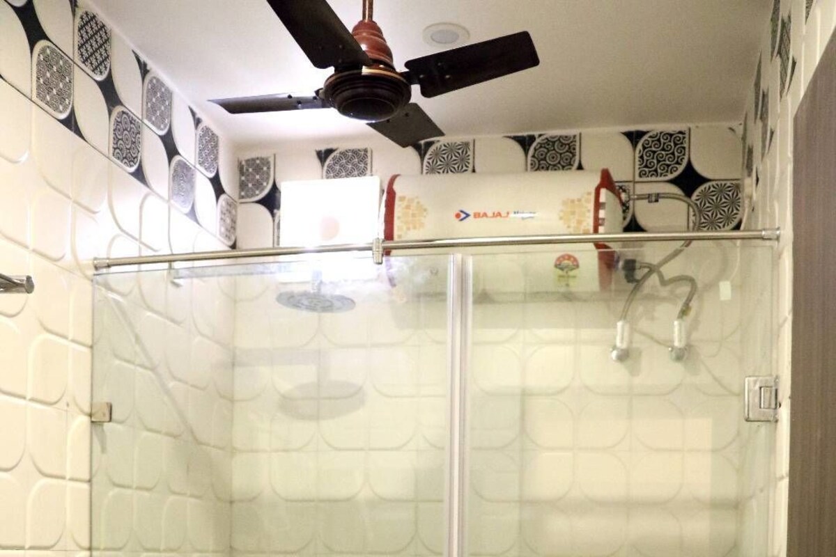 Une salle de bain avec une douche à parois de verre, des toilettes et un lavabo.