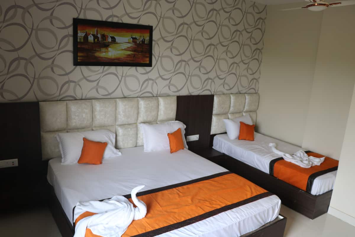 A hotel room with two beds, a large headboard, and a painting on the wall.
