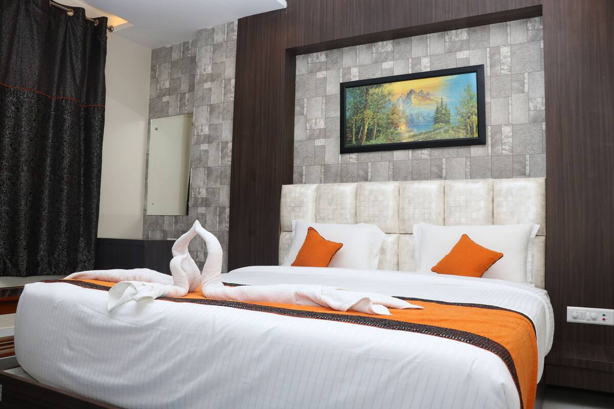 A hotel room with a large bed, a painting on the wall, and a modern design.