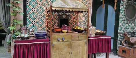 A traditional market stall with a canopy, a vintage cart, and a table with various items.