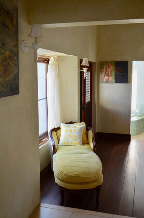 A room with a bed, a window with curtains, a lamp, and a painting on the wall. - Villas at Indigo Reef (West End Village)