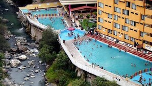 A hotel with multiple swimming pools, a river, and a bridge. - Hotel MH (Chignahuapan)