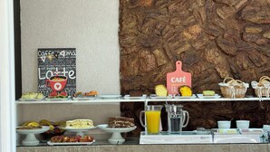 A breakfast buffet with various pastries, cakes, and a coffee station. - Pousada Vovô Nino (Gramado)