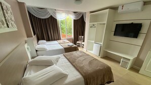 A hotel room with two beds, a wardrobe, a television, and a window with curtains. - Pousada Vovô Nino (Gramado)