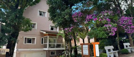 A multi-story building with a garage, a balcony, and a signboard with the name 'VOVÔ NINO.'