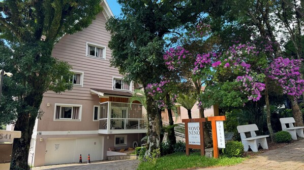 A multi-story building with a garage, a balcony, and a signboard with the name 'VOVÔ NINO.' - Pousada Vovô Nino (Gramado)