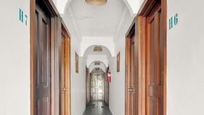Un pasillo con puertas de madera identificadas con H7 y H6, que dan a habitaciones.