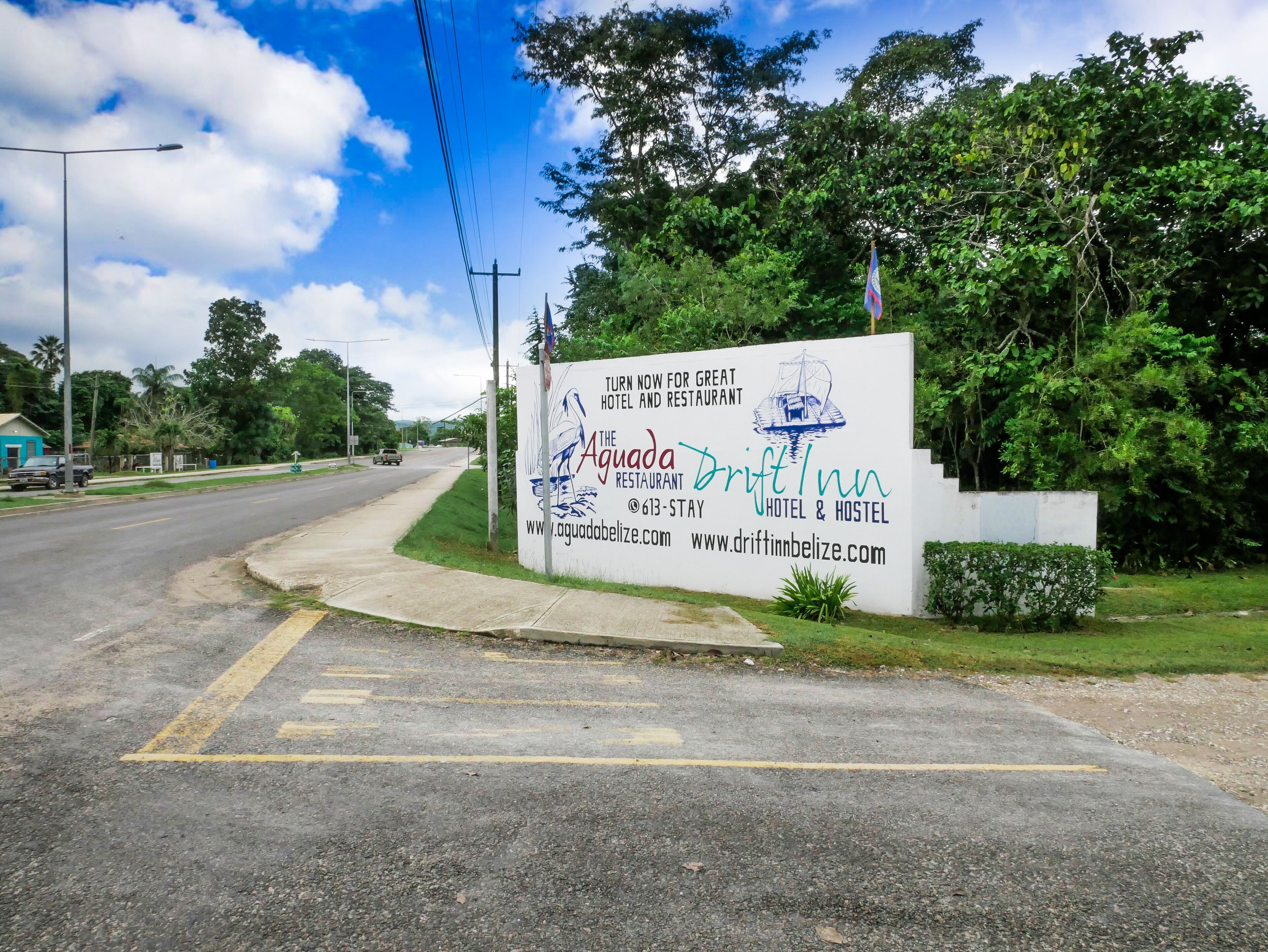 Un cartel para The Aguada Drift Inn, un hotel y albergue con información de contacto y sitios web.