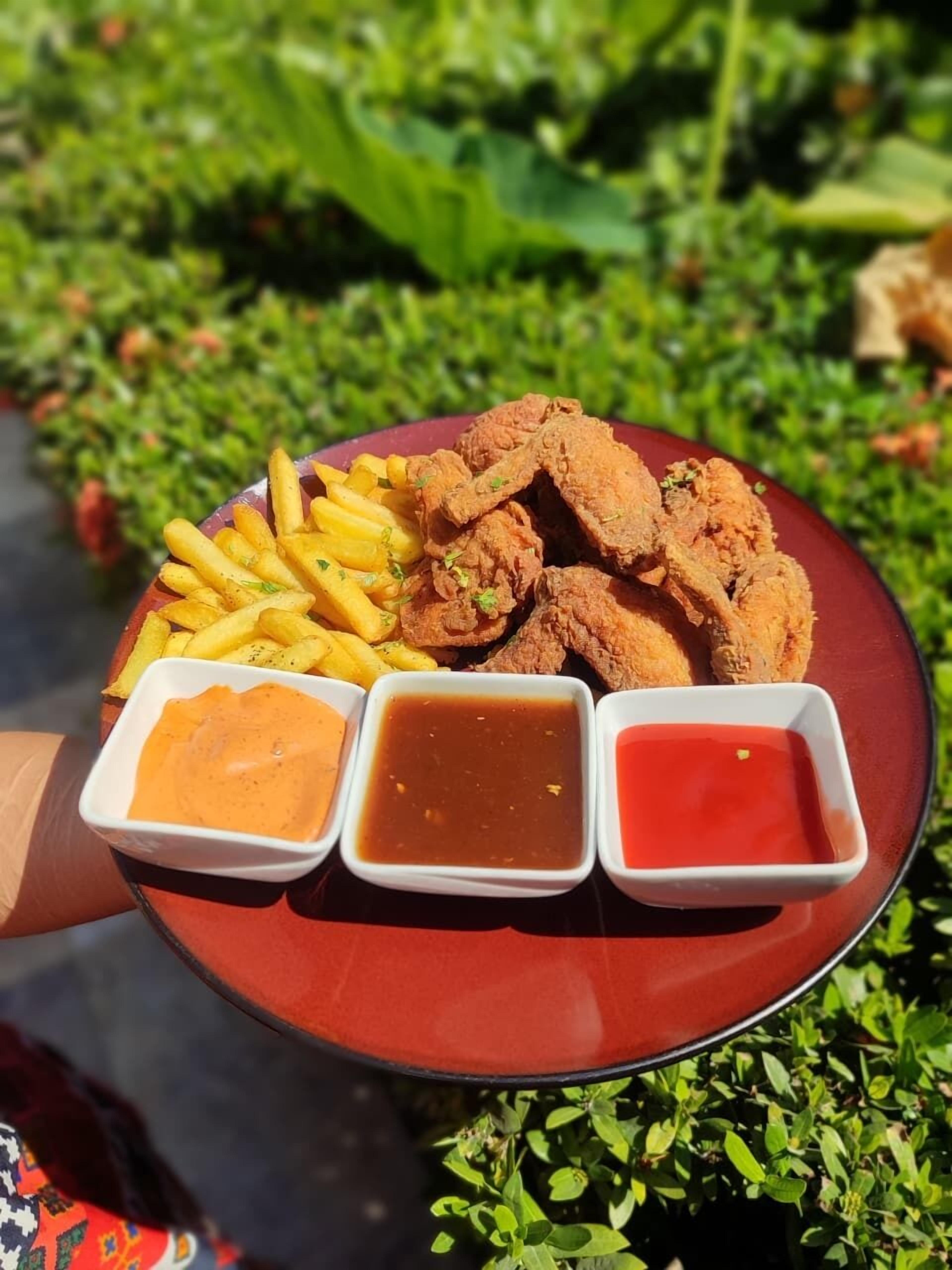 A plate of fried chicken, French fries, and three dipping sauces.
