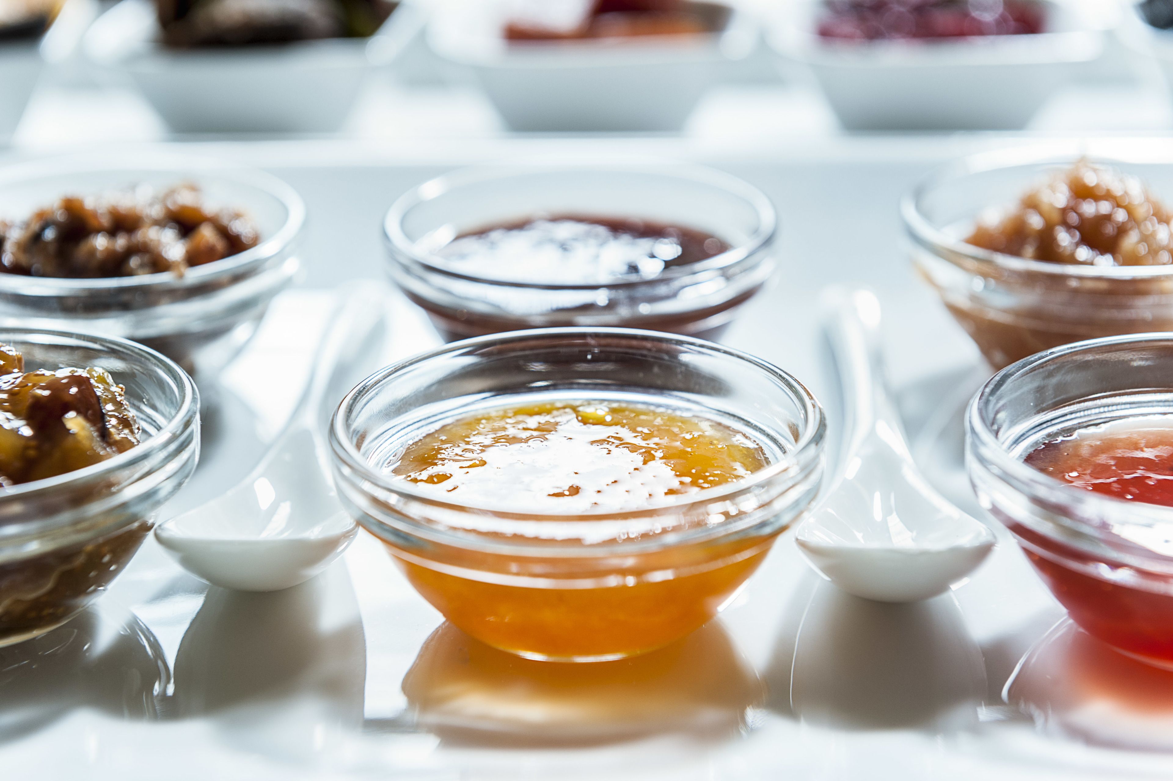 A table with various small bowls containing different types of condiments.