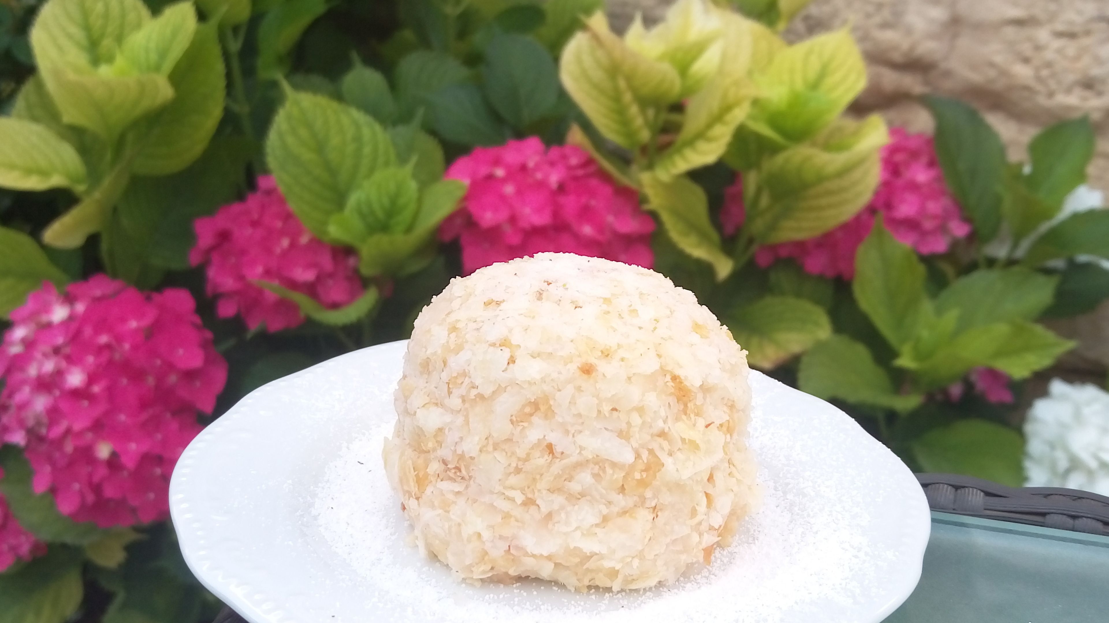 A white plate with a mound of white rice on a white tablecloth.