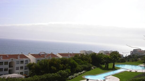 A residential area with a swimming pool, a view of the sea, and buildings with red roofs. - Puerto Velero Andrea Meza 2 (Coquimbo)