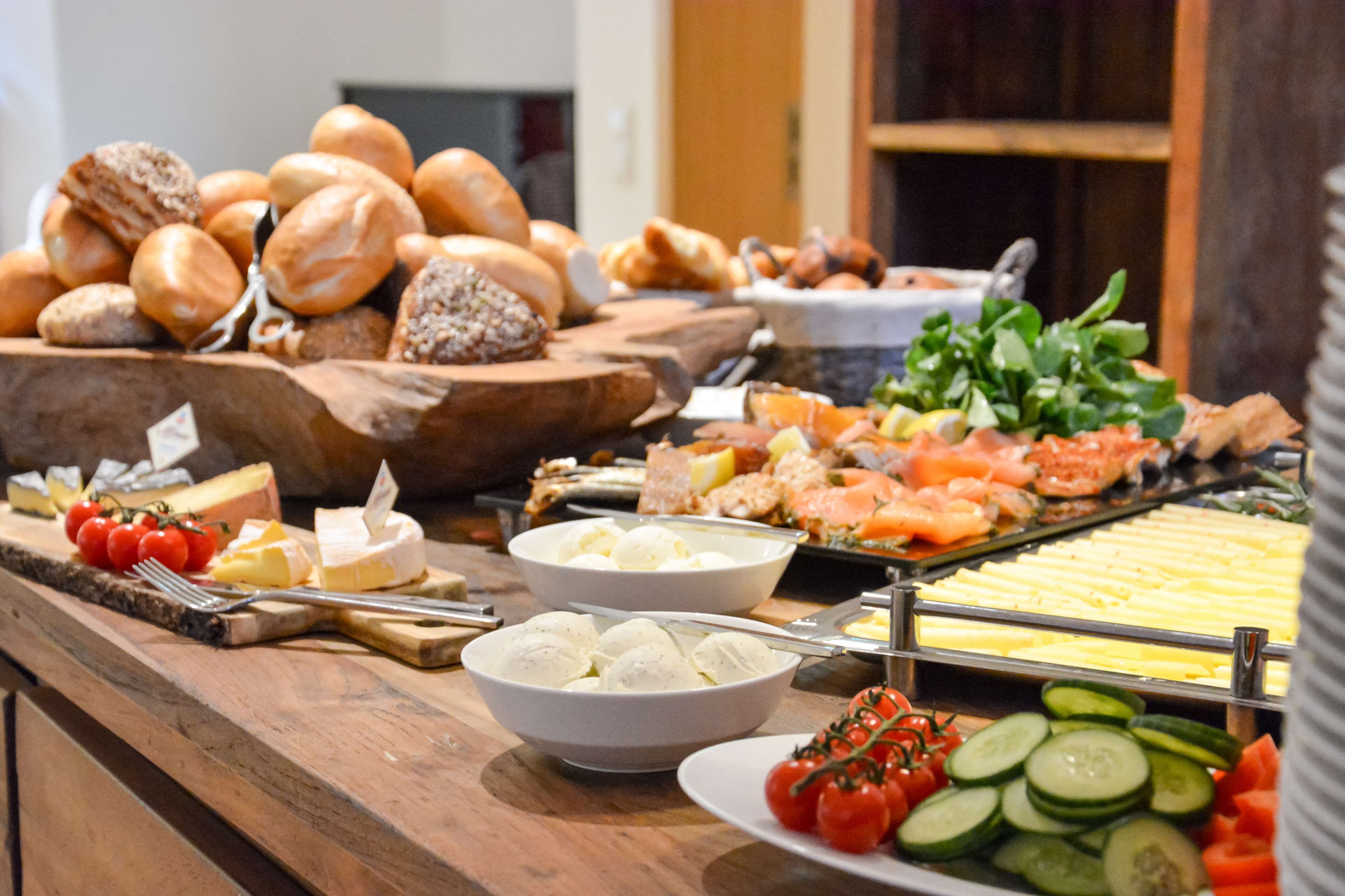 A buffet with various food items including bread, cheese, and vegetables.
