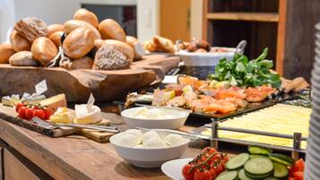 A buffet with various food items including bread, cheese, and vegetables.