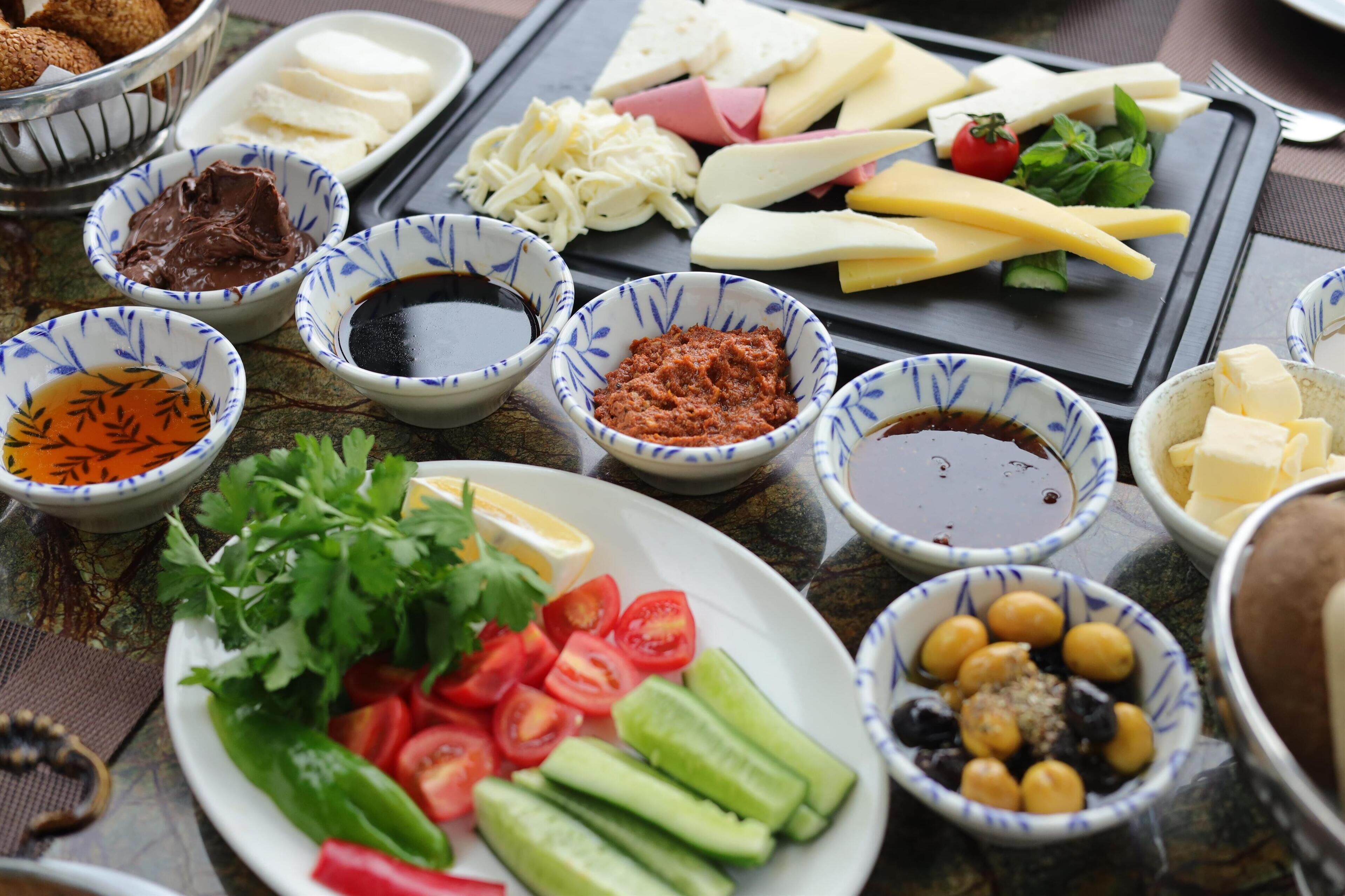 Une variété d’aliments, notamment des fromages, des olives et des légumes, disposés sur une table.