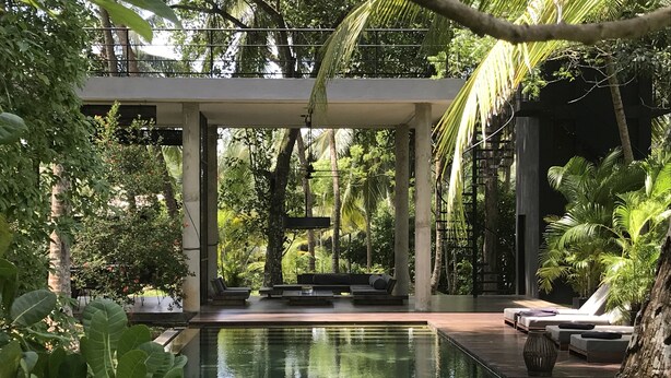 A modern outdoor pool area with lounge chairs and a seating area surrounded by lush greenery. - KAJU GREEN eco lodges (Unawatuna)