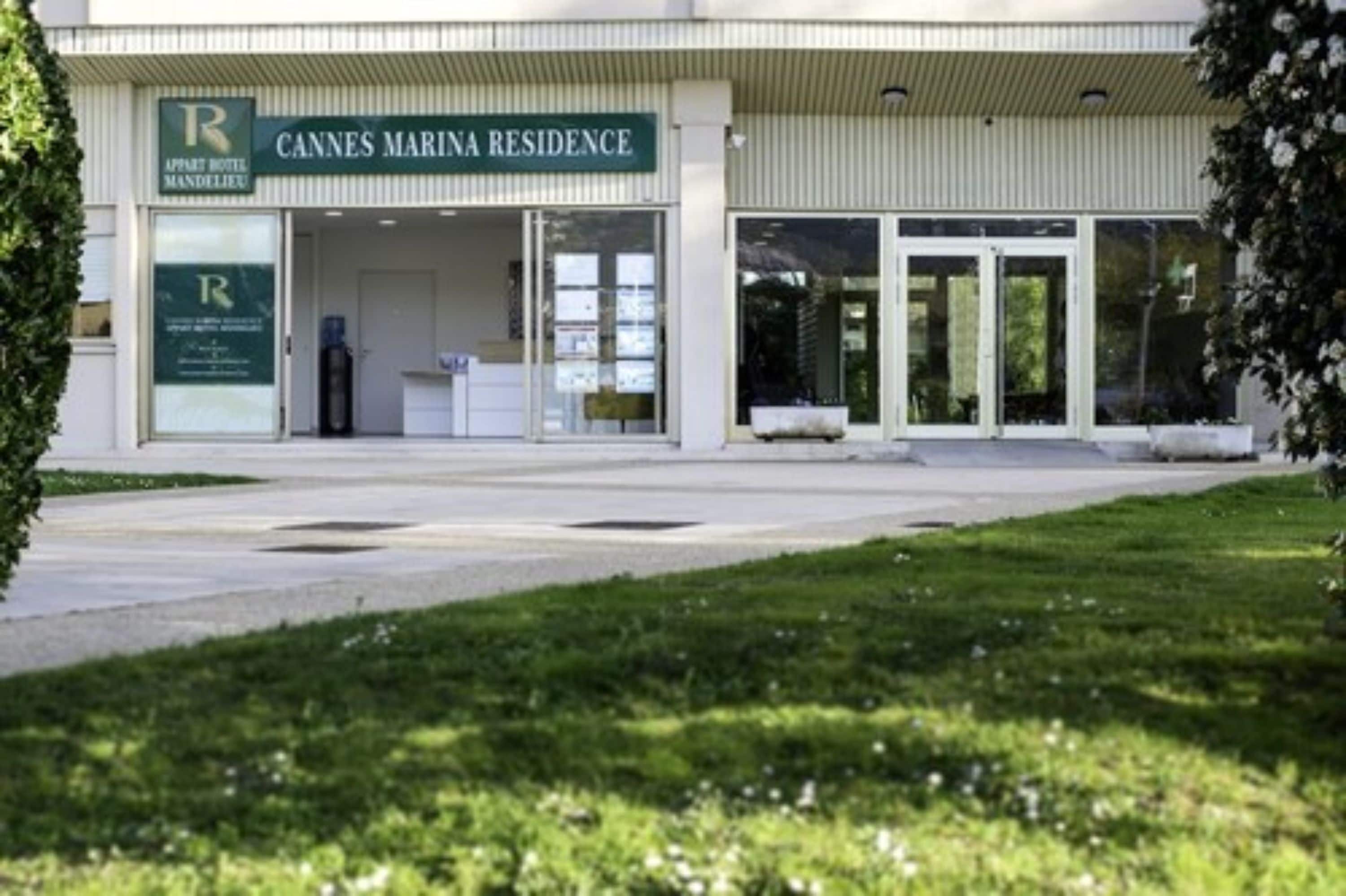 A modern building with a sign reading "Cannes Marina Residence."